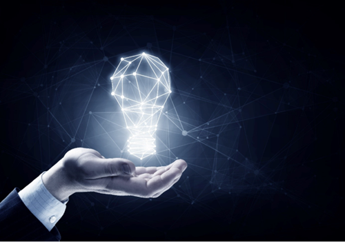 Hand hält eine leuchtende, polygonale Glühbirne aus Linien und Punkten vor dunklem Hintergrund, die ein digitales Netzwerk und Innovation symbolisiert.